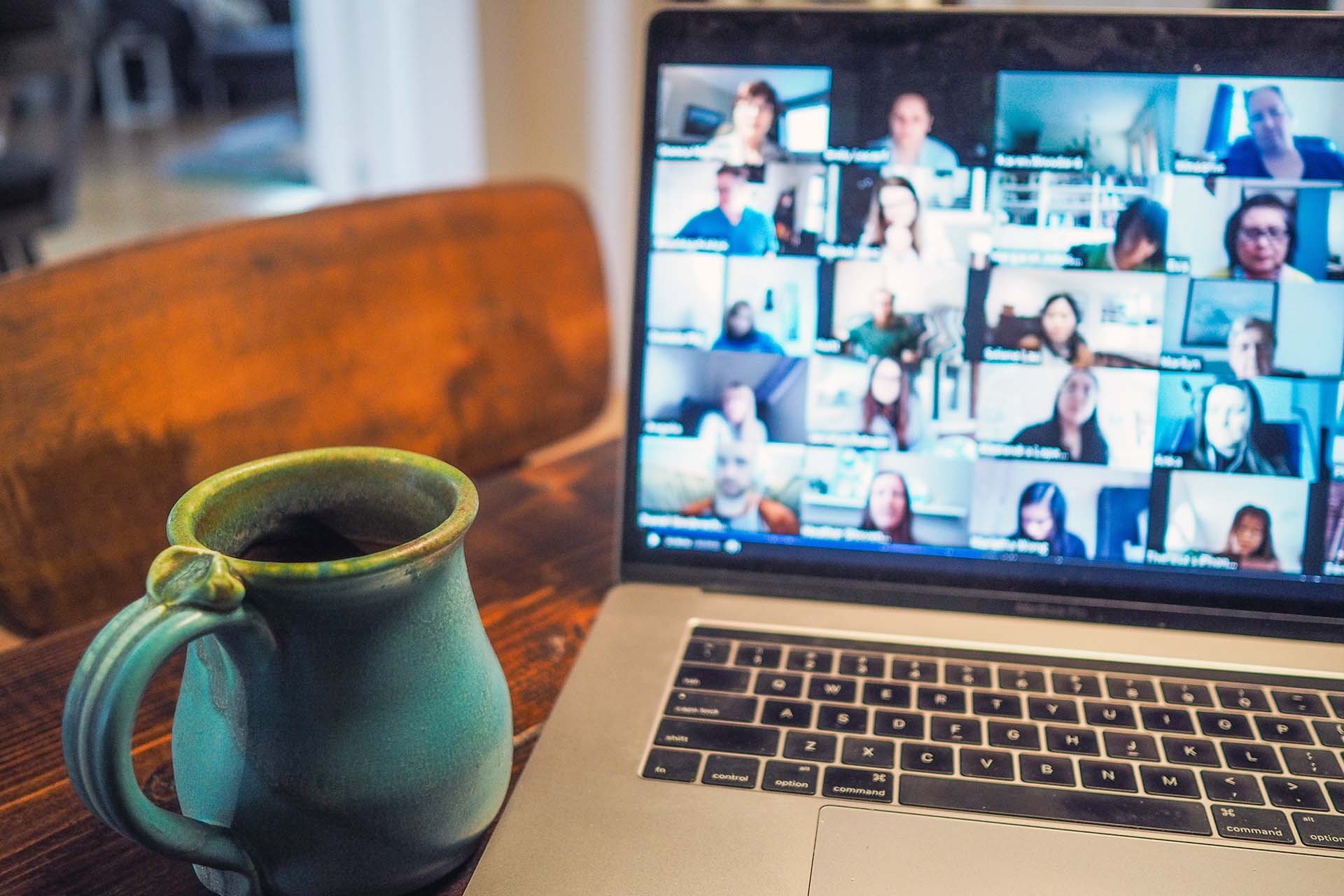 Mug by a laptop with video chat.